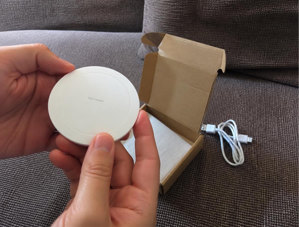 Manos sosteniendo el cargador Winergy recién sacado de su caja, con el cable micro-USB al lado